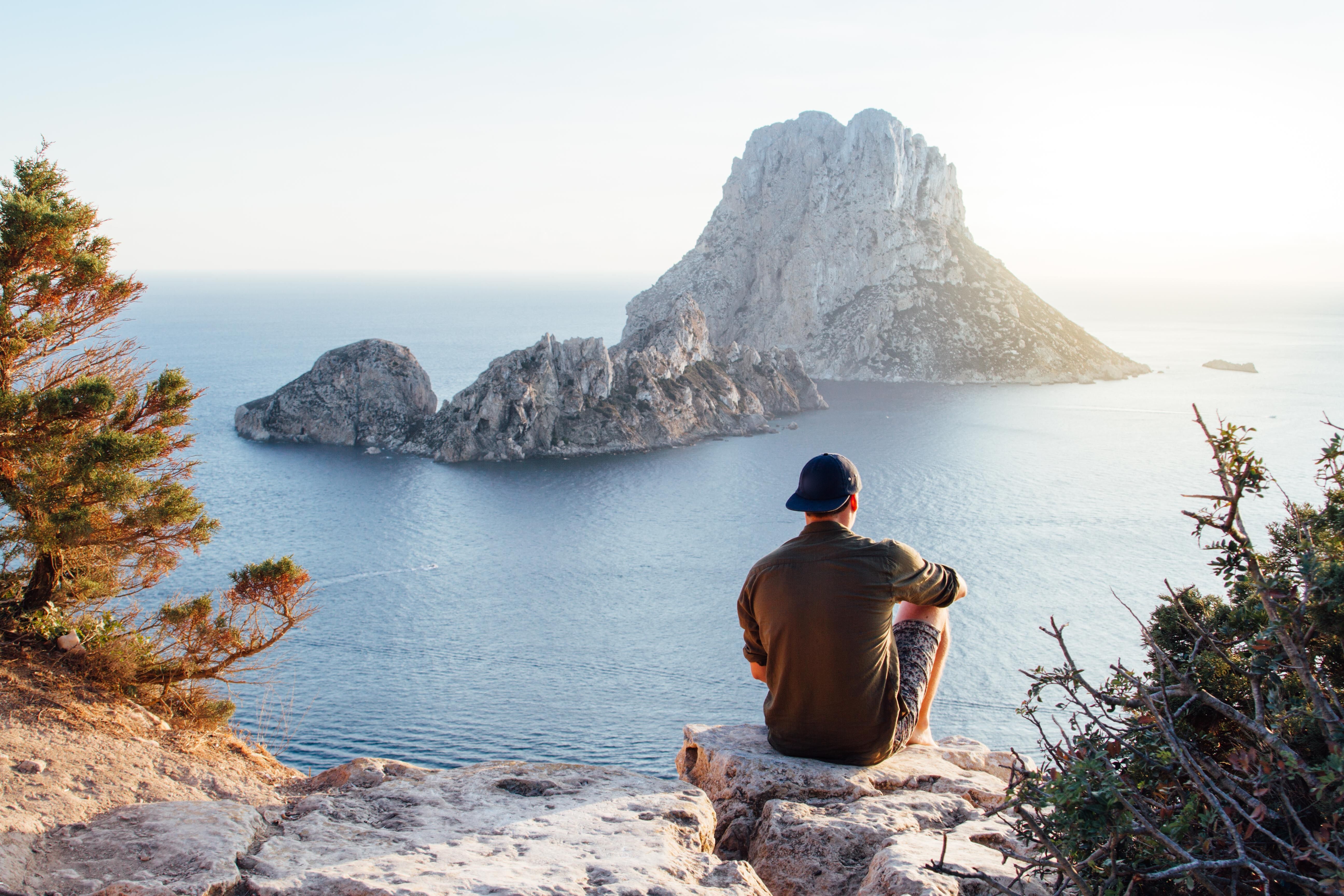 Man sitting on a rocky coastal overlook
